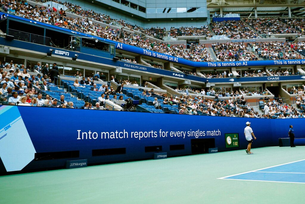NEW YORK — The U.S. Open is adding a new layer of artificial intelligence to its digital fan experience, with IBM and the United States Tennis Association announcing new tools on August 24, 2026. The new features are designed to help fans follow matches with less effort. They will appear through the U.S. Open website and official app during this year’s tournament. The goal is simple. Tennis can produce a huge amount of data during a single day. Fans may want scores, player form, key points and match trends at the same time. The new AI tools aim to turn that data into clear information that is easier to use. One new feature is a more personal Live Updates home page. It is designed to help fans find the matches, players and updates that matter most to them. Instead of searching through many pages, users can get a more focused view of the tournament. Another tool is an AI based Serve Quality measure. It will give fans more context about the quality of a player’s serve. Serve speed is only one part of tennis. Placement, spin and the result of the serve can also affect a point. A data tool can bring those details together in a simple format. The U.S. Open is also expanding Key Moments insights. The feature is meant to highlight important parts of a match. That can help fans who do not have time to watch every point. It can also give regular viewers a quick way to understand why a match changed direction. An upgraded Match Chat assistant is another part of the new system. It is designed to answer questions about matches and players in a more direct way. Fans can use it to explore information while following live action. The use of AI is becoming a major part of sports coverage. Tennis is especially suited to data tools because every point can create a large set of numbers. Serve speed, rally length, shot location and score changes can all be used to build a picture of a match. The U.S. Open has already used AI and data systems for years. Its digital products have offered match predictions, live statistics and other insights. The new tools push that work further by putting more personalized information in front of fans. IBM said the 2026 system is expected to generate about 1.2 billion data points. That figure shows the scale of the event and the technical task behind its digital services. The challenge is not only collecting data. It is also making that data useful without making the fan experience too complex. Trust will be important. AI can process information quickly, but sports fans also need accurate results. Match scores, player statistics and other official information must be reliable. The system therefore works with tournament data and the event’s editorial process. The timing is also important. The 2026 U.S. Open is entering its main event period, with mixed doubles action taking place before the singles draw. The singles tournament is scheduled to run from August 30 through September 13 in New York. The new AI tools may also change how casual fans watch tennis. A person who knows little about the sport can use simple explanations to understand a match. A serious fan can use deeper numbers to follow tactics and form. There is a wider business reason for the change as well. Sports events compete for attention across phones, streaming services and social platforms. Fast and useful digital features can help an event keep fans engaged for longer. AI does not replace the match itself. The players still decide the result on court. The technology works around the action by helping fans understand what they are seeing. As the tournament grows, that role may become more important. More matches mean more data and more choices for fans. The new system is designed to reduce that overload and make the U.S. Open easier to follow. For tennis, the August 24 announcement shows how quickly AI is moving from a side tool to a central part of sports coverage. The test now will be whether these features are fast, clear and accurate when the biggest matches begin.